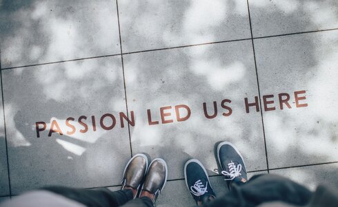 Füße auf Beton mit Aufschrift Passion Led Us Here